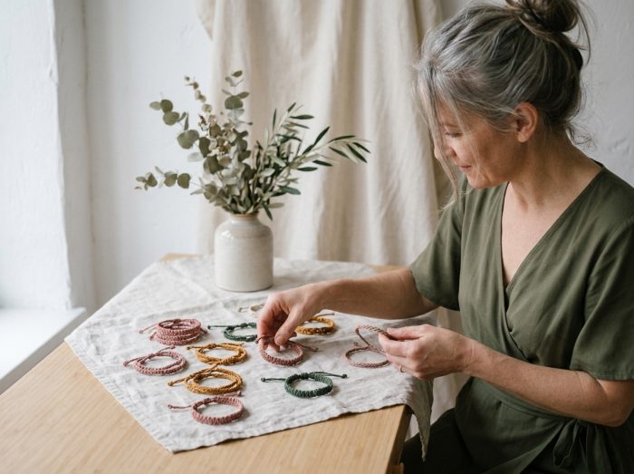 Femme élégante choisissant des bracelets en cordon artisanaux dans un espace boutique minimaliste